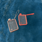 Two clear flask shaped water bottles made by sips in Coral and Taupe floating in blue waters. The perfect water bottle to take on holiday.