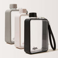 Three Sips water bottles with textured protective bumper in grey, light grey, and black, arranged in a row against a plain background. The perfect bottle for your gym sessions.
