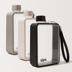 Three Sips water bottles with textured protective bumper in grey, light grey, and black, arranged in a row against a plain background. The perfect bottle for your gym sessions.